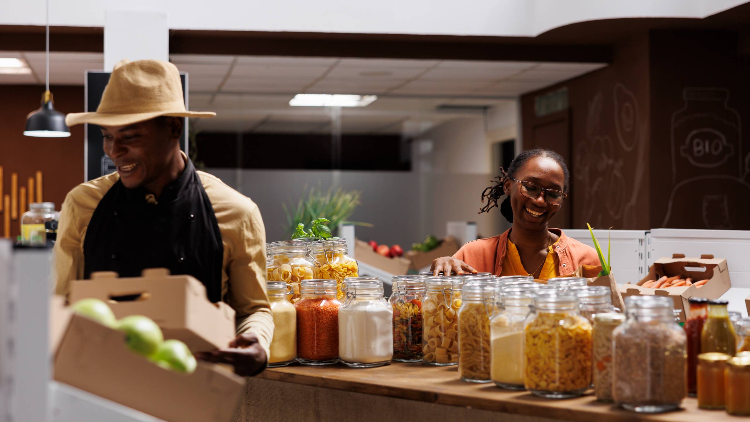 A shop owner restocking the counter while a customer browses